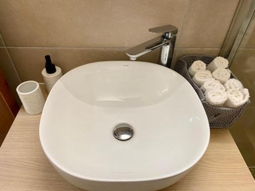 a white bathroom sink with a basket of toilet paper at INCREDIBLE VIEW in Larnaka