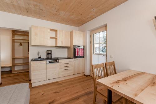 uma cozinha com armários de madeira e uma mesa de madeira em Salzkristall - Ferienwohnung em Haus im Ennstal