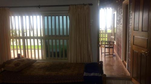 a living room with a large window and a door at Delta Hospitality - Sea facing rooms with a PRIVATE BEACH in Kalyānpur