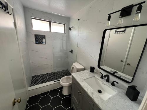 a white bathroom with a sink and a toilet at Large Pool & Patio Cozy Single Story Family House in Las Vegas