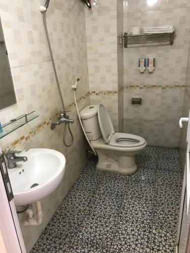 y baño con aseo y lavamanos. en KHÁCH SẠN HÀ ANH 1 NỘI BÀI, en Noi Bai