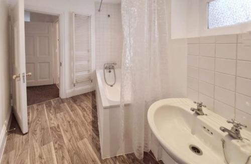 a white bathroom with a sink and a window at Private Double Bedroom in King's Cross St Pancras in London