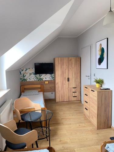 a small attic room with a bed and a desk at Hostel w ogrodzie in Grudziądz