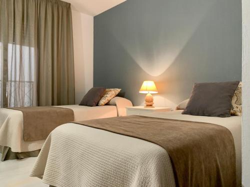 a hotel room with two beds and a window at Benabola Hotel & Suites in Marbella