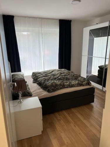 1 dormitorio con cama y ventana grande en Schöne Eigentumswohnung mit Terrasse en Lübeck