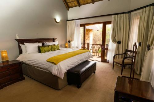 a bedroom with a large bed and a balcony at The Citrine House 33 in Mabula