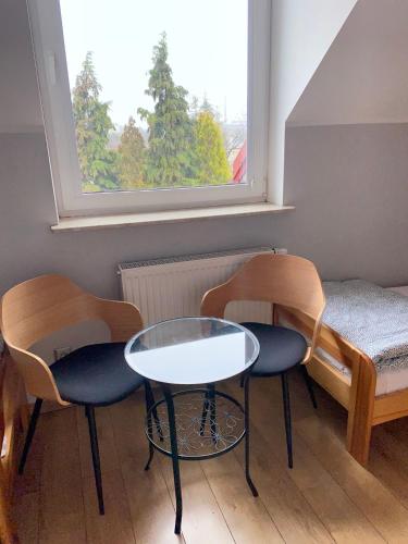 a room with two chairs and a table and a window at Hostel w ogrodzie in Grudziądz