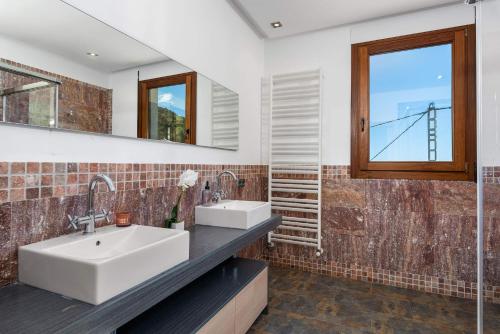 a bathroom with two sinks and a window at Villa Anis - PlusHolidays in Calpe