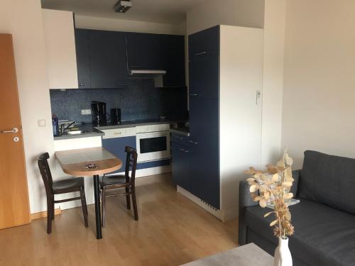 een keuken en een woonkamer met een tafel en een bank bij MF City Apartment in Korneuburg