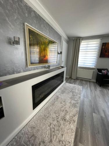 a living room with a fireplace and a painting on the wall at Stadtblick Neuruppin in Neuruppin