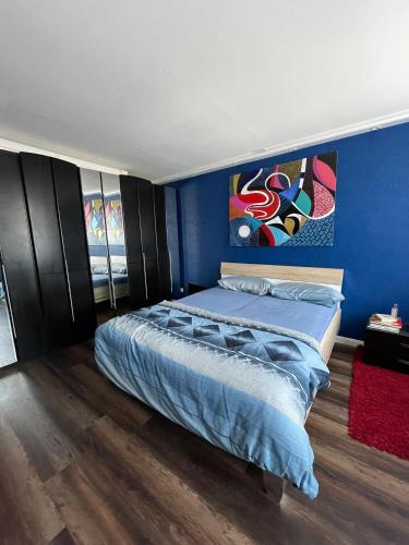 a bedroom with a bed and a blue wall at Stadtblick Neuruppin in Neuruppin