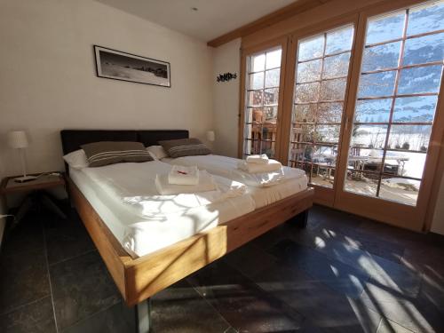 a large bed in a room with windows at Billabong in Grindelwald