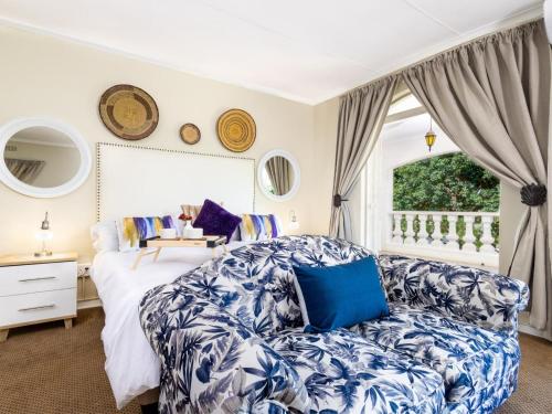 a bedroom with a bed and a couch at Wölfe Krantz Luxury Accommodation in Nelspruit
