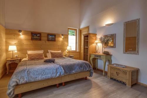 a bedroom with a bed with a blue comforter at Panoramic Village - Locations vue Glaciers - Chez Philippe in La Grave
