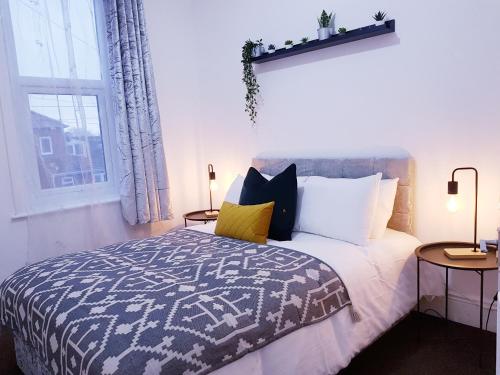 a bedroom with a bed with pillows and a window at The Birchington - 3 Bedroom Apartment & Workspace in Westoe