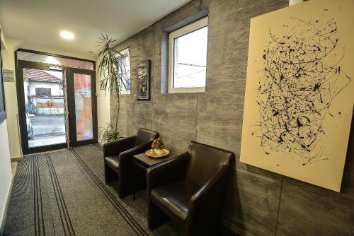 a waiting room with leather chairs and a painting at Villa ARS in Belgrade