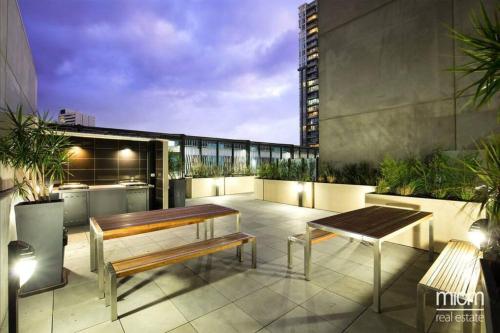 a patio with benches and tables on a building at Stylish Southbank apartment Plus Free Parking for 2 Cars in Melbourne