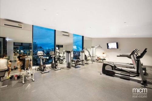 a gym with several treadmills and machines in a room at Stylish Southbank apartment Plus Free Parking for 2 Cars in Melbourne