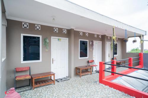 a room with a balcony with tables and chairs at RedDoorz at Oro Oro Ombo Batu in Tlekung