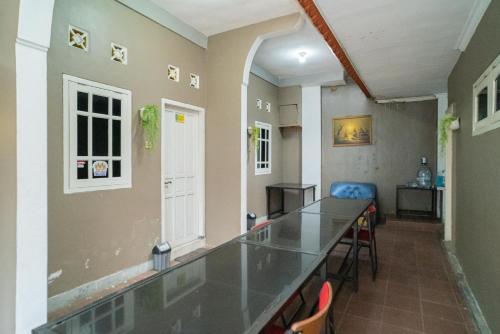 a kitchen with a counter and chairs in a room at RedDoorz at Oro Oro Ombo Batu in Tlekung