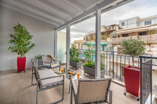 einen Balkon mit Tischen und Stühlen und Blick auf ein Gebäude in der Unterkunft Exarchia House Project in Athen