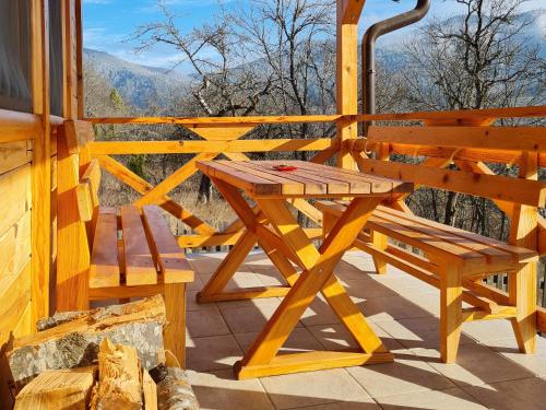 a wooden picnic table and bench on the porch of a cabin at Guest House Rankić in Mokra Gora
