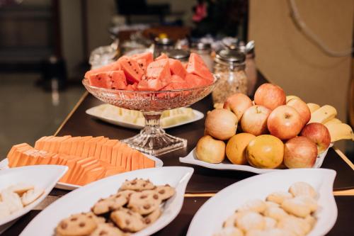 una mesa cubierta con platos de comida con frutas y hortalizas en Trindade Plaza Hotel, en Trindade