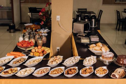 un buffet de diferentes tipos de comida en una mesa en Trindade Plaza Hotel, en Trindade