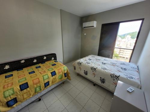 ein kleines Schlafzimmer mit einem Bett und einem Fenster in der Unterkunft Ótimo apto Enseada Guarujá in Guarujá