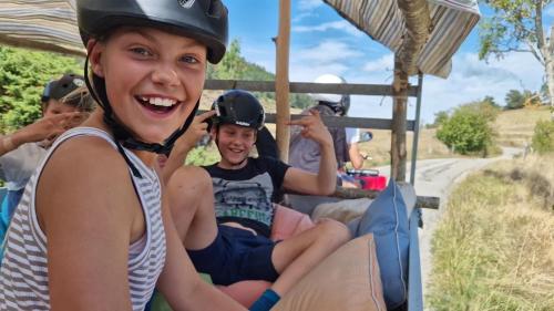 a girl smiles while riding on a zipline at Le Silence du Midi in Comus
