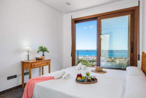 a bedroom with a bed with a view of the ocean at Villa Anis - PlusHolidays in Calpe