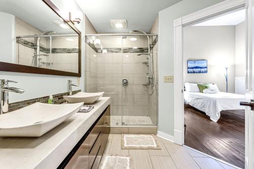a bathroom with two sinks and a shower and a bed at Elm St Retro Retreat- Downtown Close to Local Amenities in Greensboro