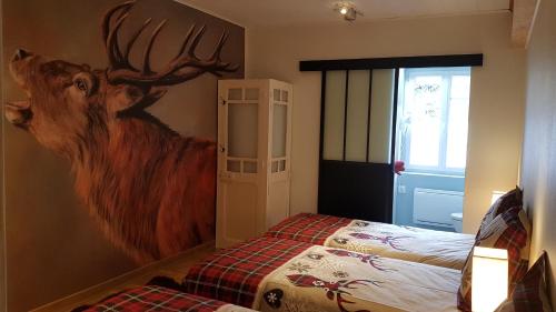 een slaapkamer met een schilderij van een hert aan de muur bij Le Silence du Midi in Comus