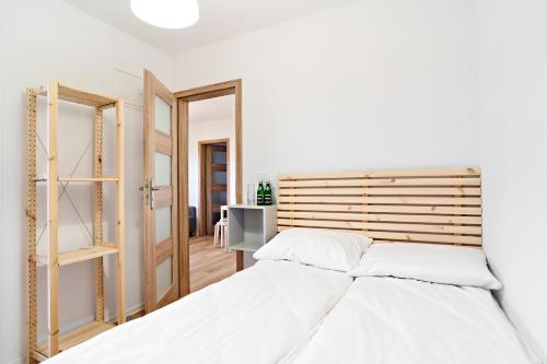 a white bedroom with a bed and a mirror at Wyspa Wisła Przyjazna Przystań Stężyca in Stężyca