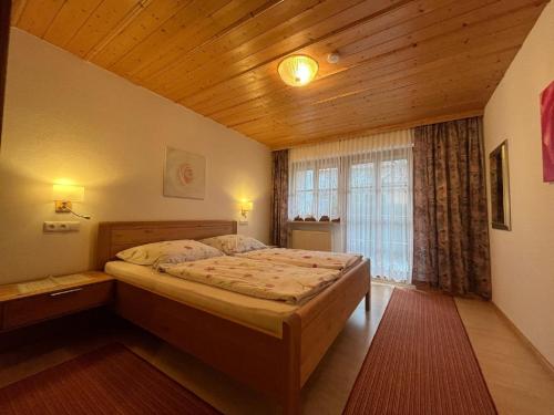 ein Schlafzimmer mit einem Bett und einer Holzdecke in der Unterkunft Ferienwohnungen und Ferienhaus Kronner in Zachenberg