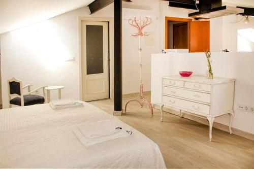 - une chambre avec un lit blanc et une commode dans l'établissement Precioso estudio, à Arenas de San Pedro