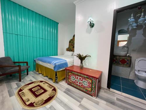 a bedroom with a bed and a bathroom with a toilet at Duet Hostel & Hotel in Karakol