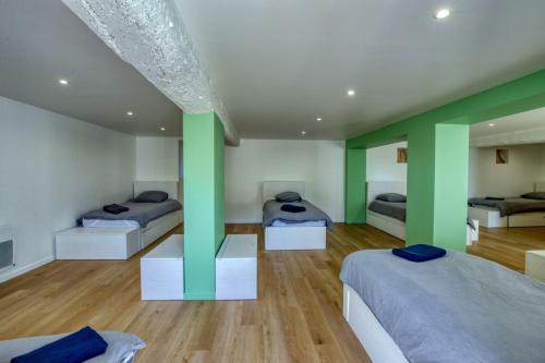 Cette chambre comprend 3 lits avec piliers verts. dans l'établissement So Villa La Girardiere 28 - Heated pool - Basket - Jacuzzi - 2h Paris - 30 beds, à La Loupe