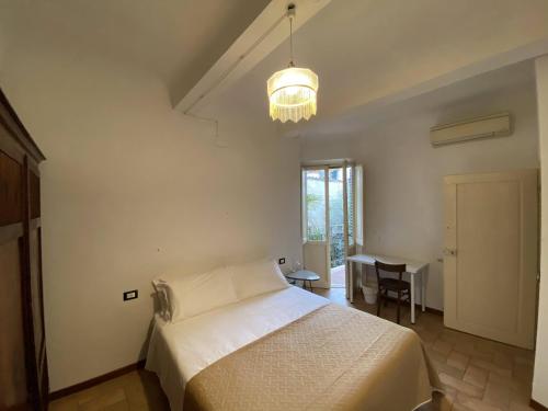 a bedroom with a white bed and a chandelier at Accademia Apartment in Florence