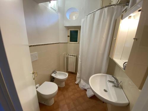 a white bathroom with a toilet and a sink at Accademia Apartment in Florence