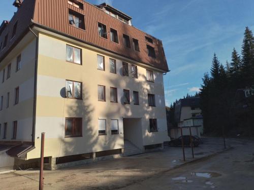 a white building with a red roof at Apartman Pahuljica Vlašić in Vlasic