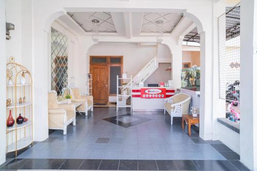 a room with chairs and a staircase in a store at RedDoorz Syariah at Aura Homestay in Ponorogo