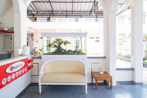a seafood restaurant with a chair and an aquarium at RedDoorz Syariah at Aura Homestay in Ponorogo