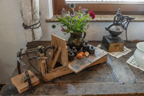 uma mesa com um vaso e algumas flores sobre ele em Erlebenswert Bauernhof Gruber em Sankt Lorenzen im Lesachtal