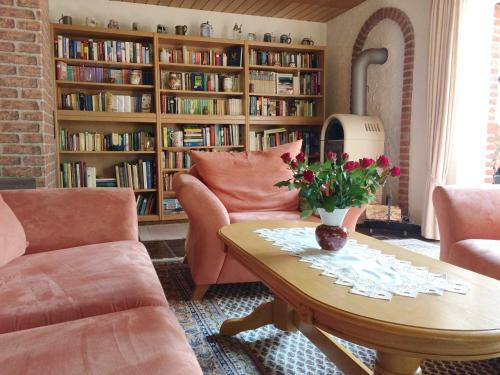 a living room with a couch and a table with flowers at Ferienhaus zum Schornsteinfeger in Bad Bevensen