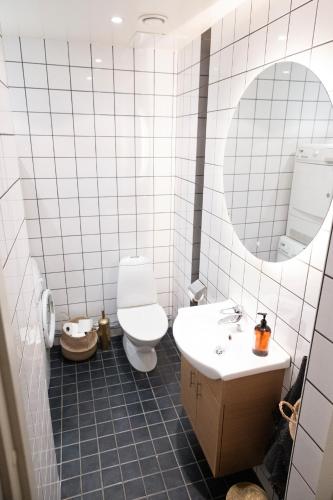 a bathroom with a toilet and a sink and a mirror at Lomma Station Inn in Lomma
