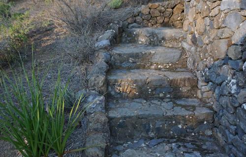 an old stone staircase next to a stone wall at Tiny House Vogelnest in Puntagorda