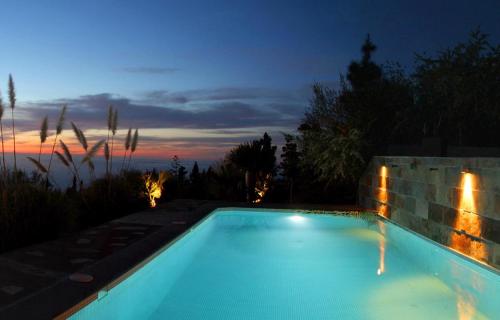 a swimming pool in a backyard at night at Tiny House Vogelnest in Puntagorda