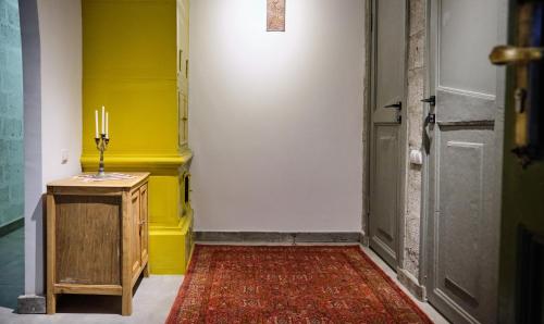 久姆里的住宿－Kotun Gyumri，一条黄色墙壁的走廊和一间带地毯的房间