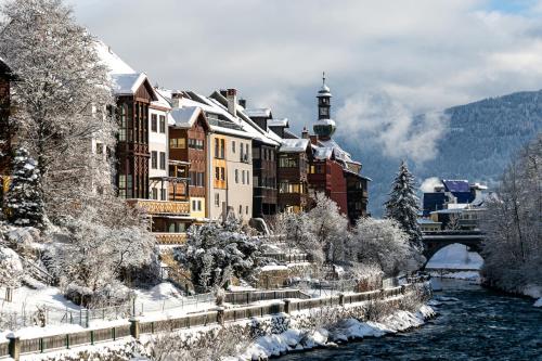 a town covered in snow next to a river at VillaJazz Apartments in Murau